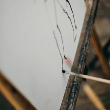 pexels photo 3778976 3778976 Close-up of a paintbrush applying strokes on a canvas set on an easel in an art studio.