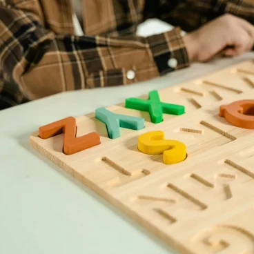 pexels photo 7333989 7333989 Wooden alphabet puzzle with colorful letters enhances fun learning for kids.